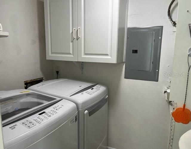 Laundry rom with new washer and dryer, electric box, water heater and storage.