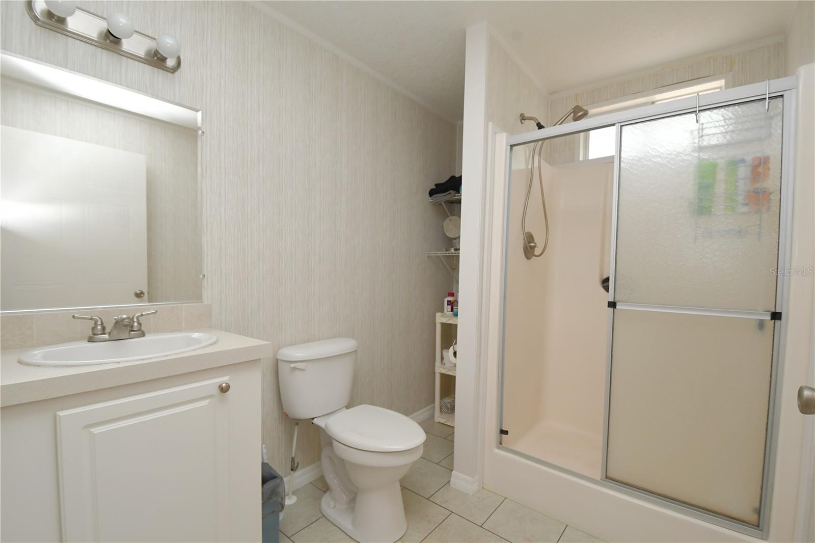 The 2nd bathroom has a walk-in shower, an upgraded Kohler commode, and a mirrored vanity with storage and lighting.