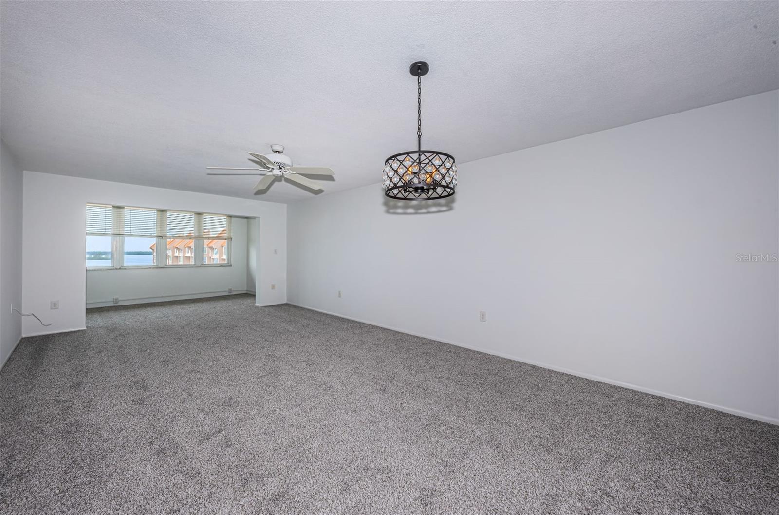 view of dining (fore front) living area (with overhead fan) and Florida room looking out onto intracoastal waterway