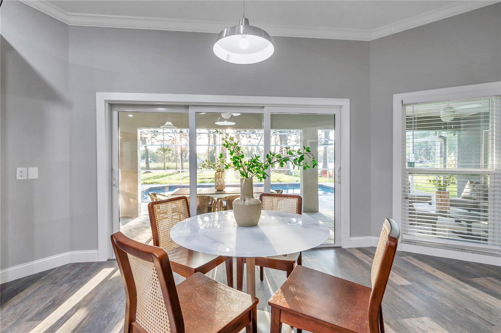 Dining room boasting natural sunlight through NEW hurricane impact windows & glass doors.