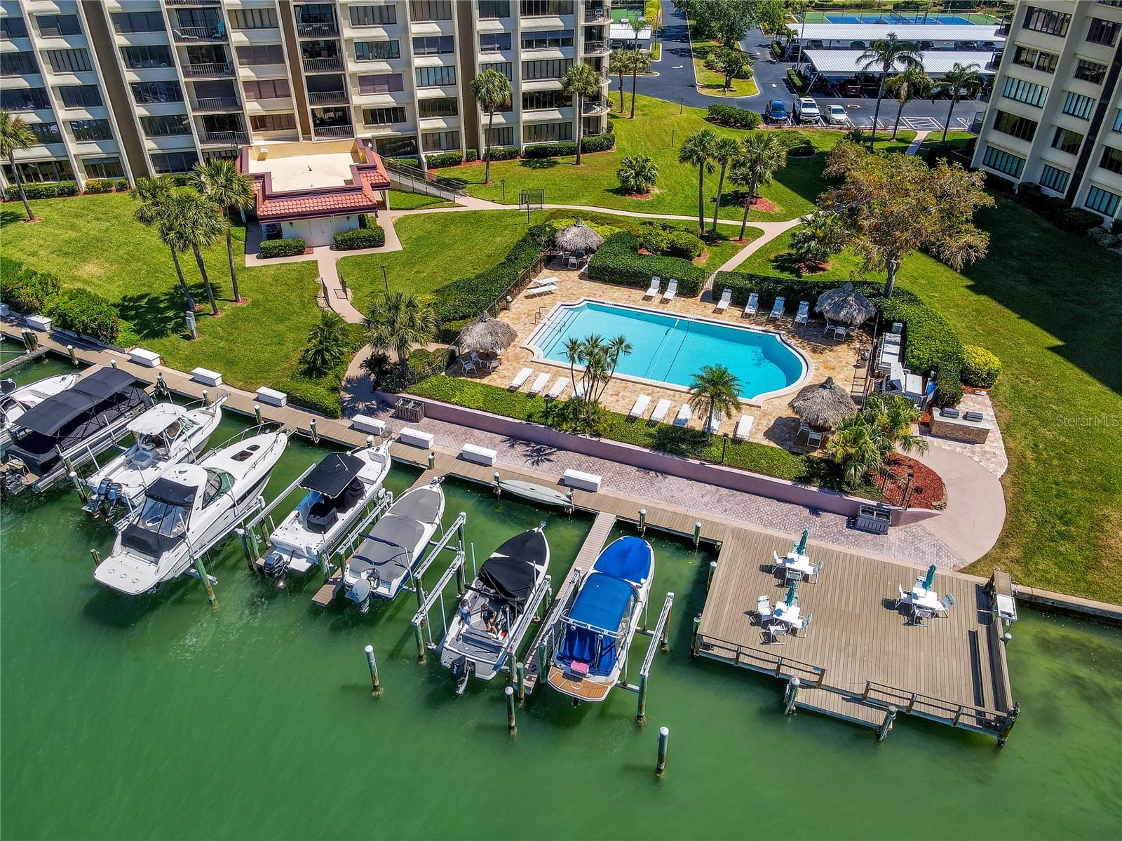 Beautiful waterfront condo building with tennis courts, heated waterfront pool, covered parking, and boat slips available for purchase when they become available.