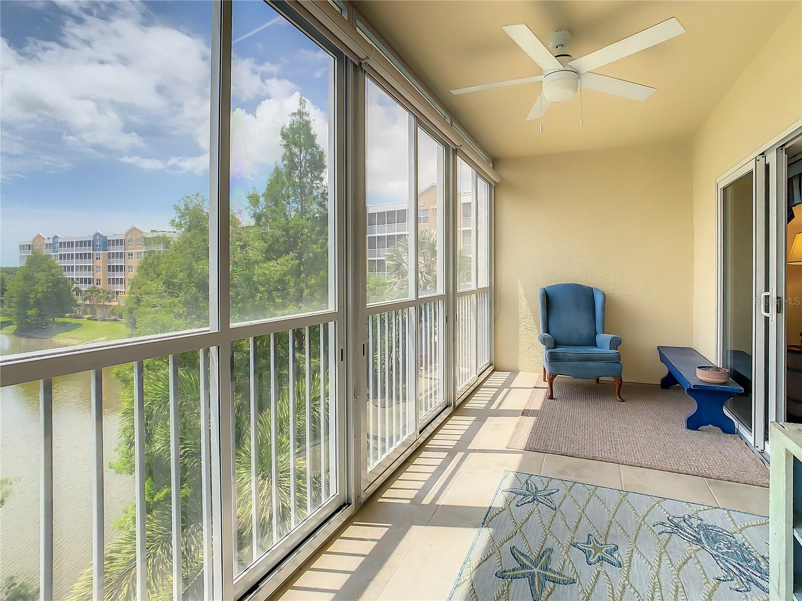 Nice-sized balcony with its upgraded screen & glass enclosure featuring enhanced blinds which can provide shade from the heat and sun without completely blocking the views or be opened to fully enjoy the picturesque golf course and pond with captivating fountain