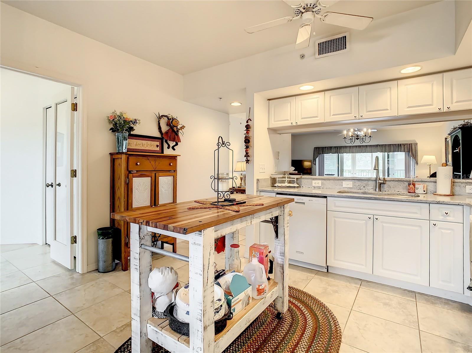 Spacious kitchen white cabinets,  updated granite countertops, and white appliances