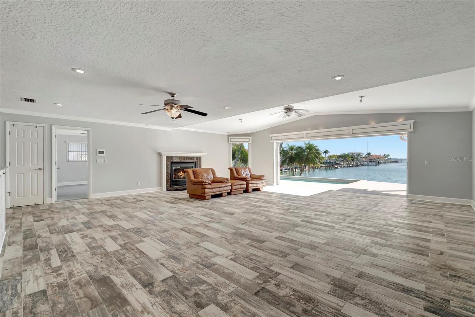Step into luxury and comfort with our expansive great room, featuring a large sliding door that opens up to the inviting pool area and mesmerizing water views beyond.