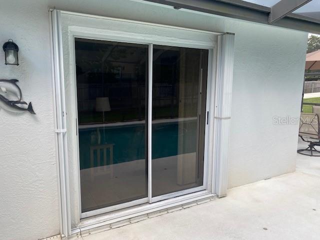 Glass doors and windows equipped with easy to close mounted Hurricane Shutters.
