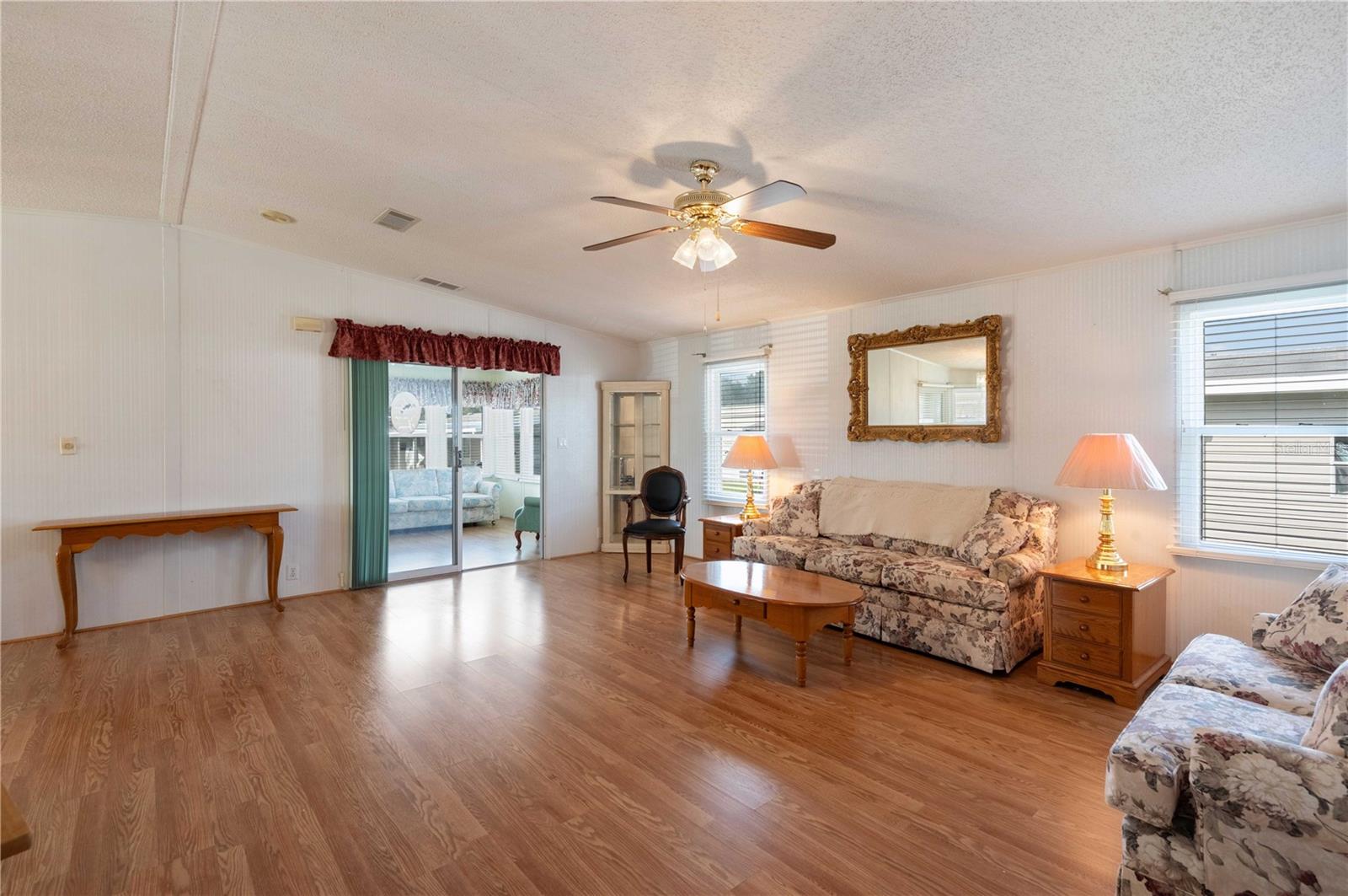 Oversized living room offers laminate flooring, ceiling fan, and great access to front Florida room.