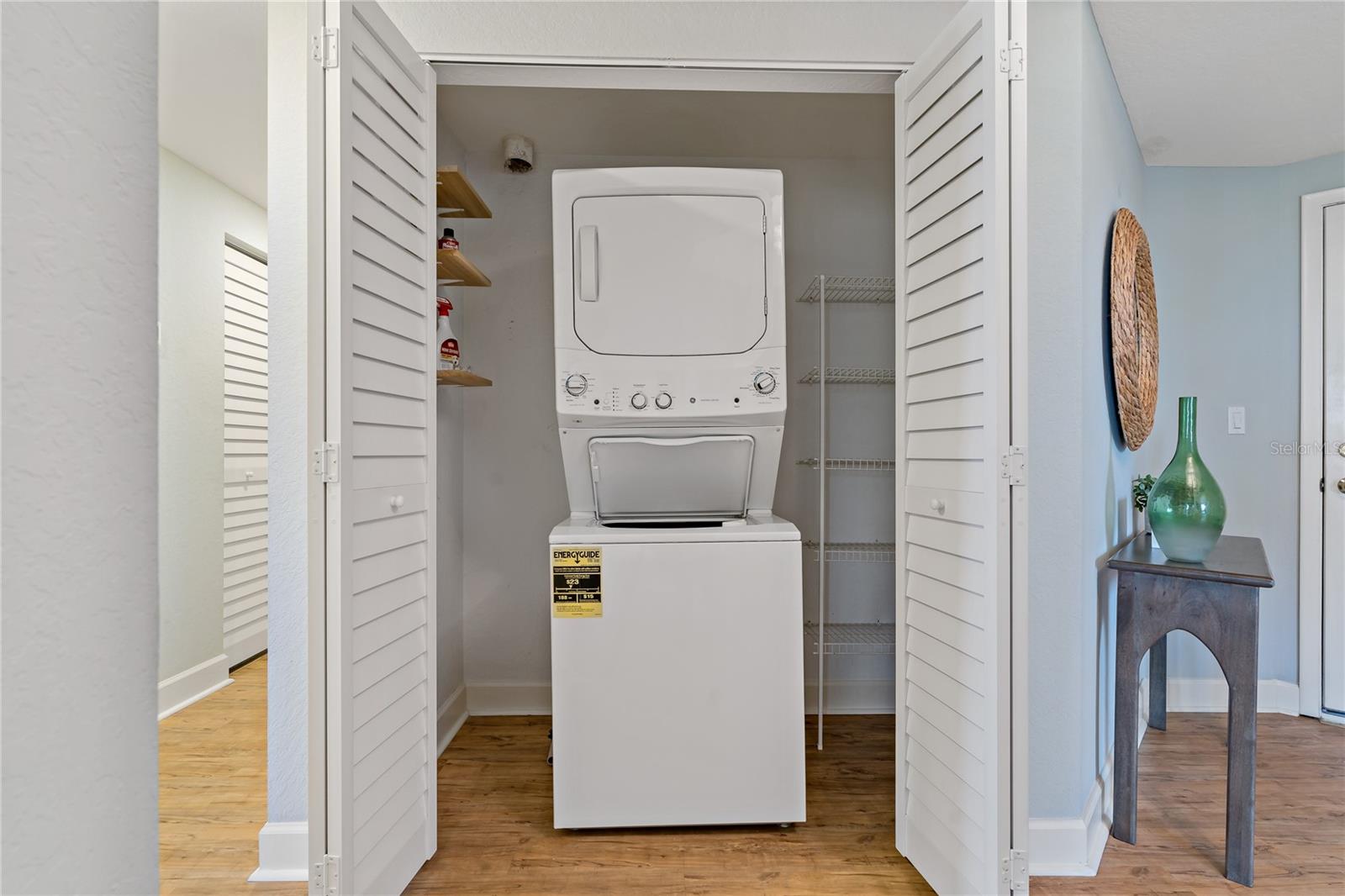 Separate laundry room with plenty of shelf space.