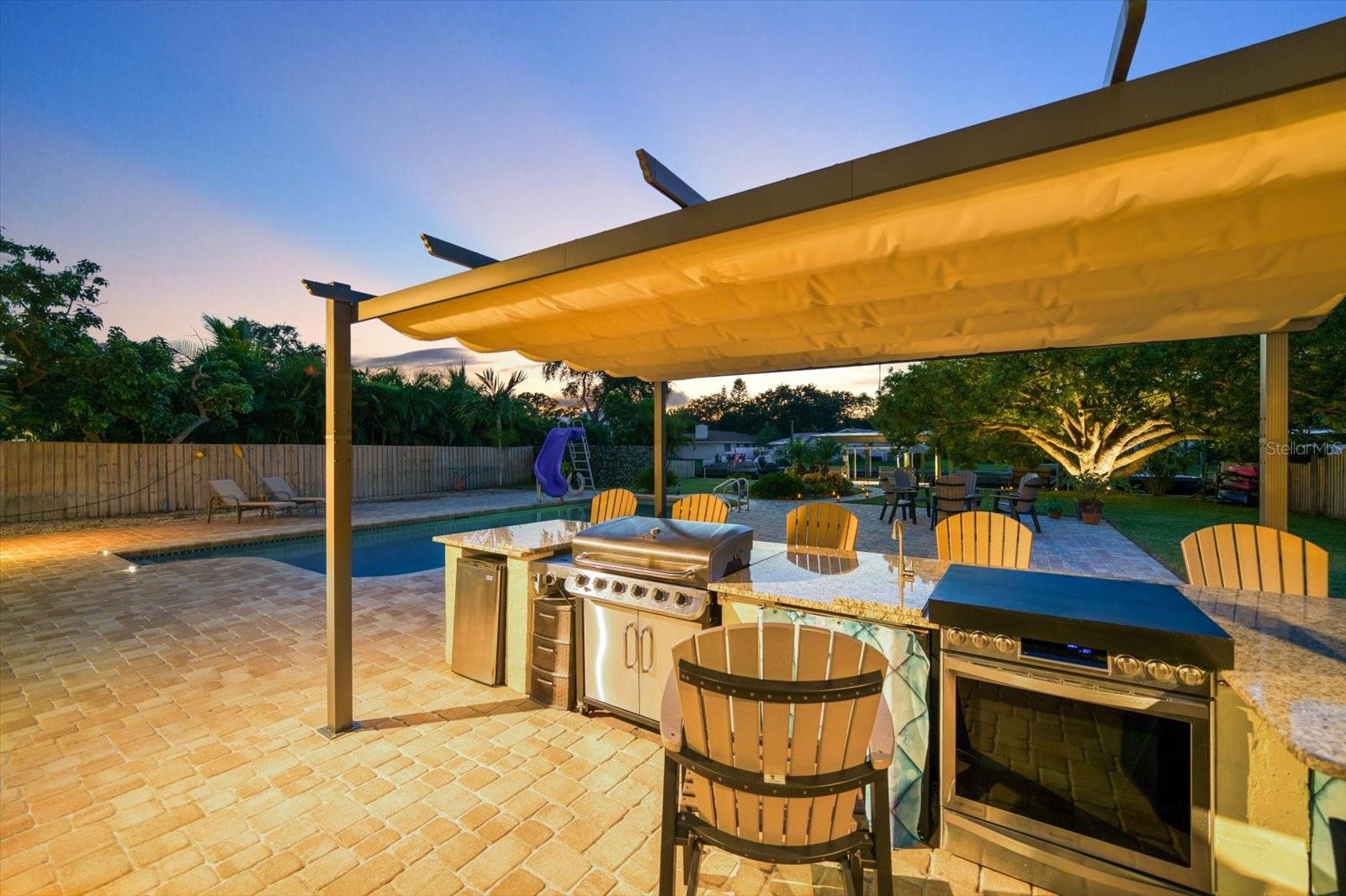Exceptional outdoor kitchen with sink, stove, range grill and refrigeration. Extensive bar for entertaining in style.