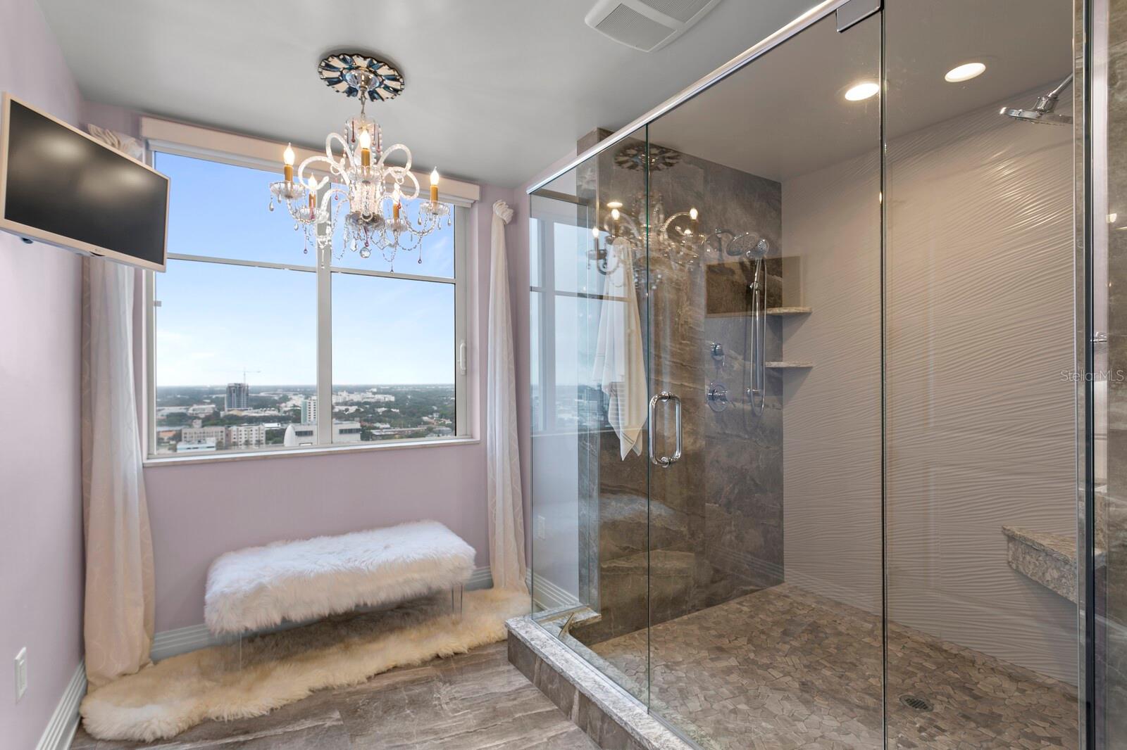 Primary Bathroom features an oversized shower with twin shower heads and custom tile.