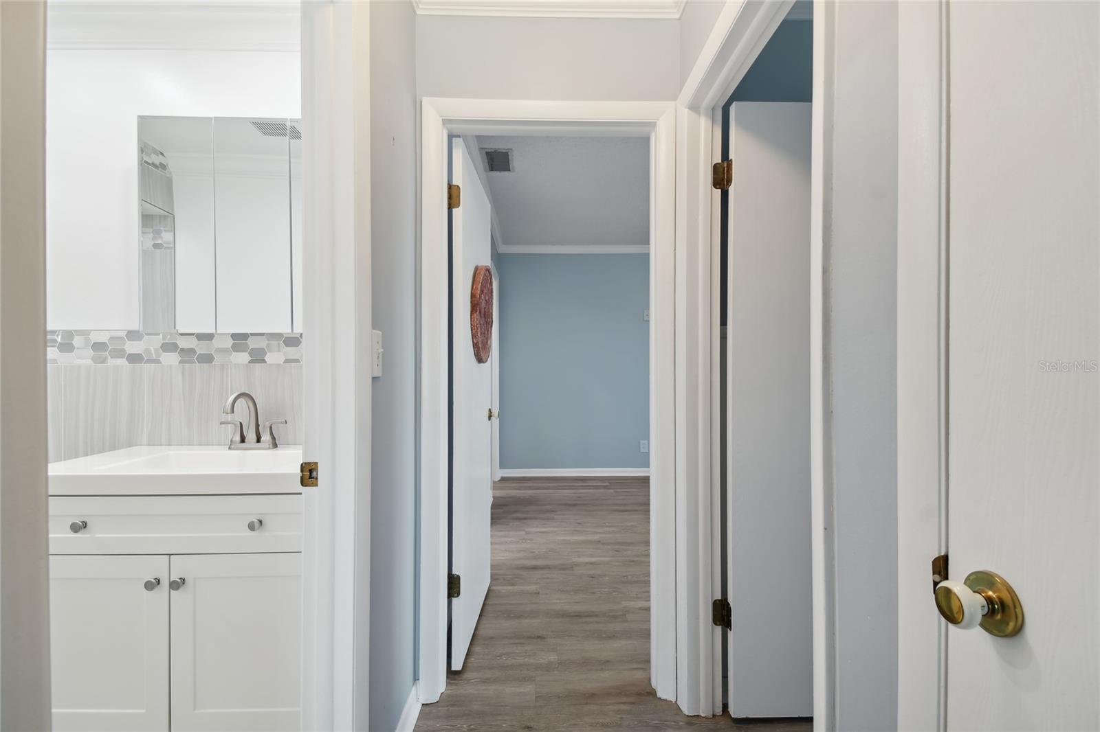 Hallway from the front entry area leading to the hall bath on the left, 2nd bedroom on the right and primary bedroom at the end of the hallway.