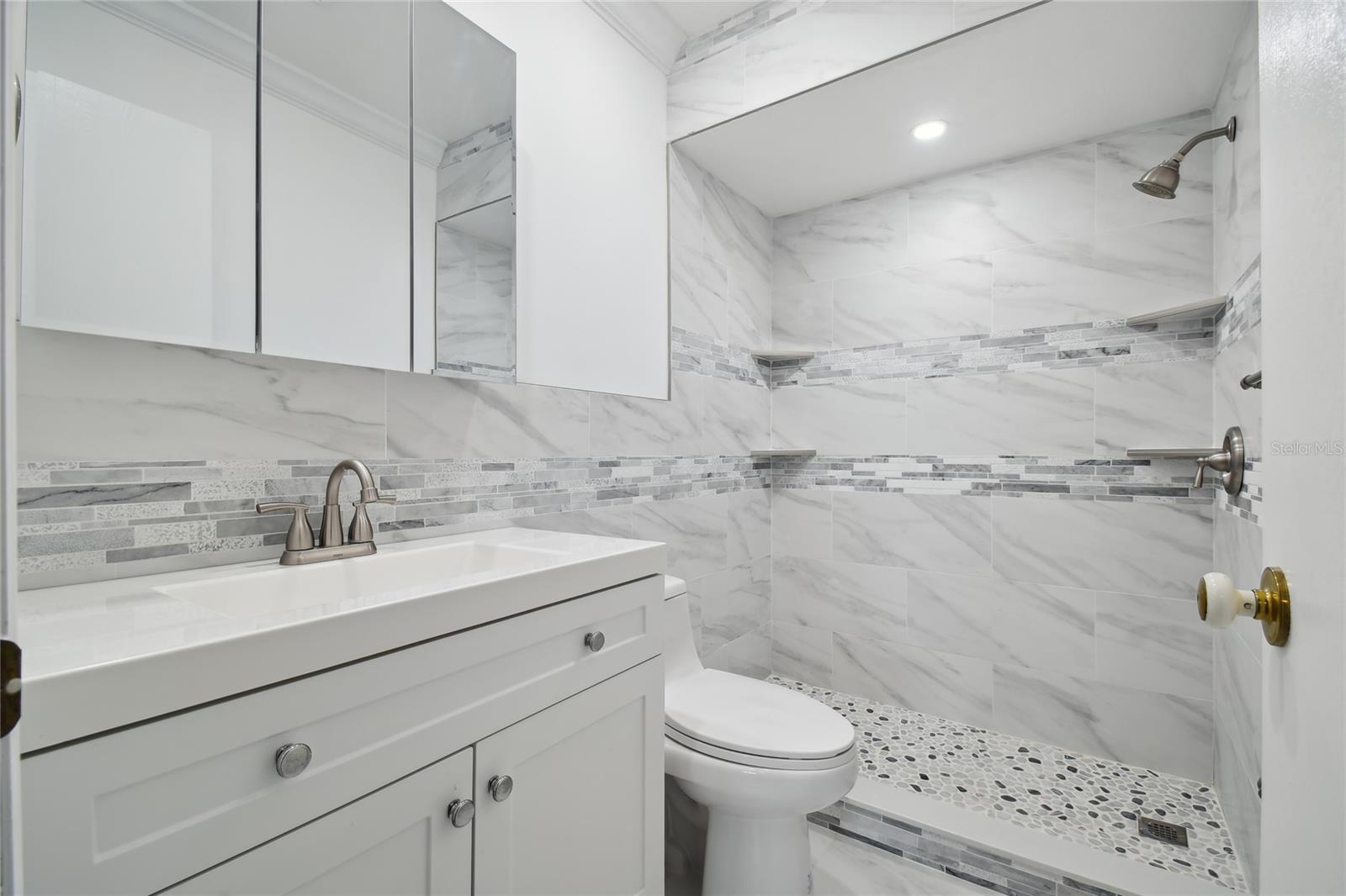 Primary bathroom with walk in shower, also was remolded a couple years ago with lovely finishes.