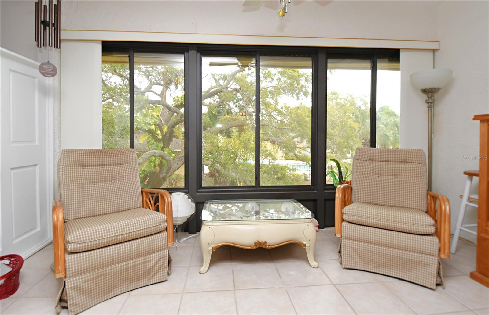 The Florida room provides a lovely view of the pool and surrounding greenery. Great area to watch beautiful sunrises every day! With double pane windows and hurricane shutters, this condo ensures safety and comfort.