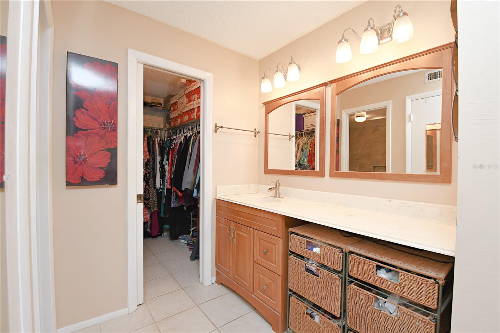 The en-suite bathroom features a large vanity featuring an extra makeup area and two mirrors.