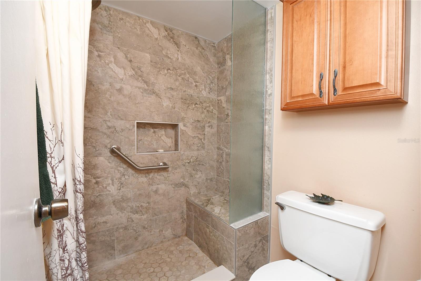 The master bedroom features an updated walk-in shower with built-in bench from 2019.