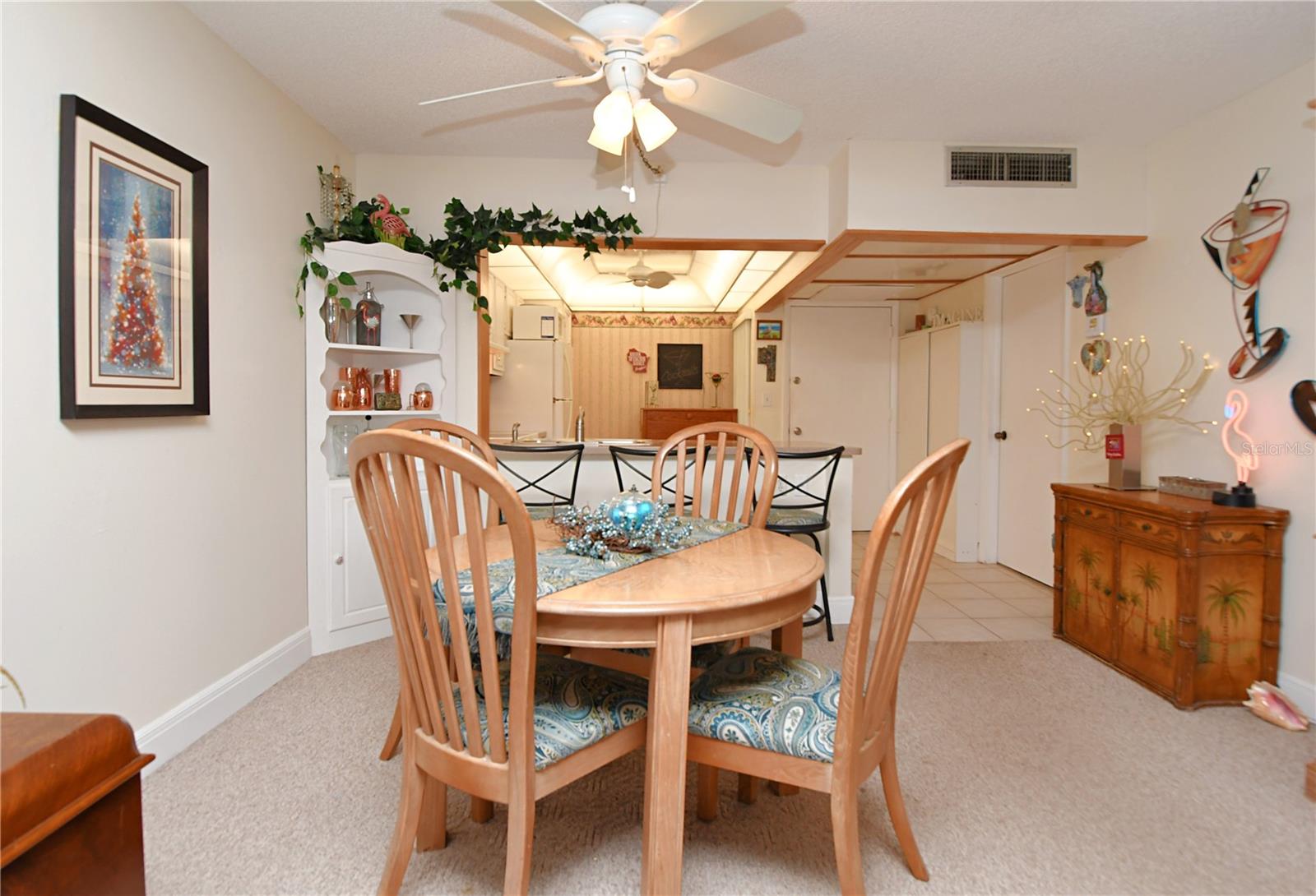 The dining room, featuring a carpeted floor and a ceiling fan, provides a comfortable and inviting space for entertaining guests.