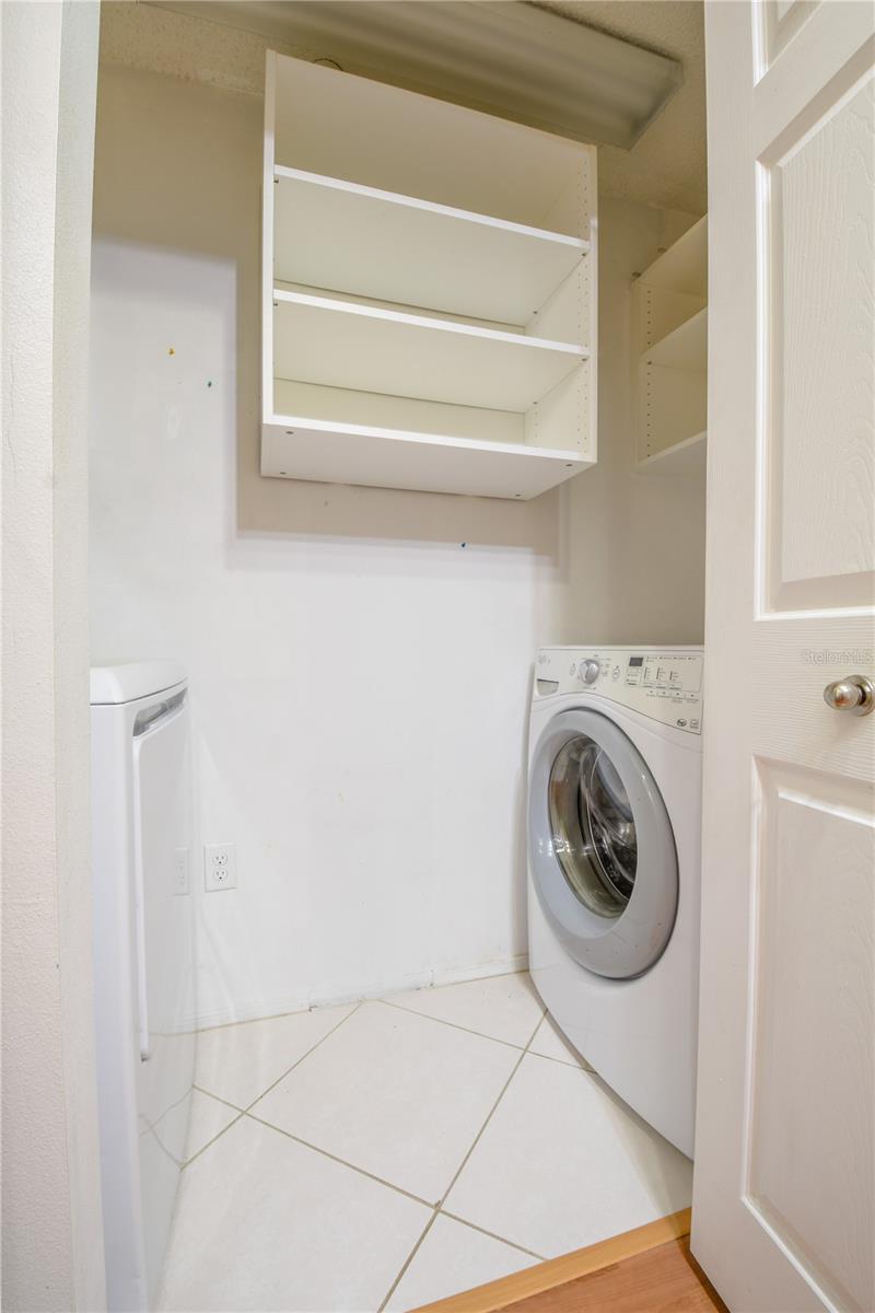 The laundry features a washer, dryer and shelving.