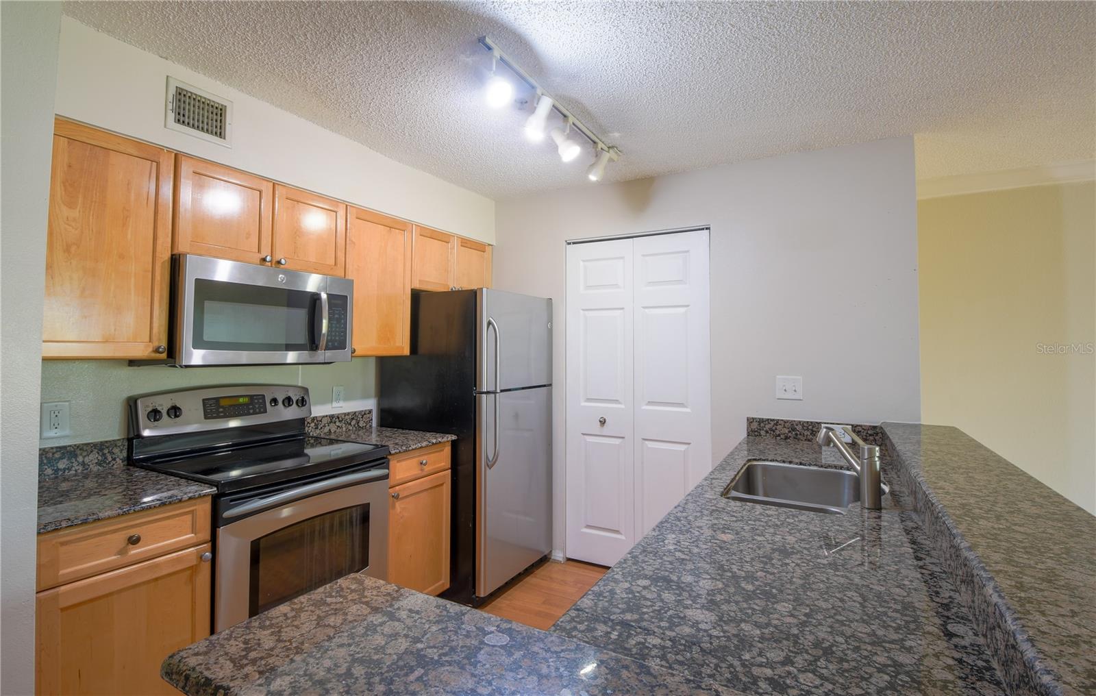 The kitchen has wood cabinetry and granite countertops.