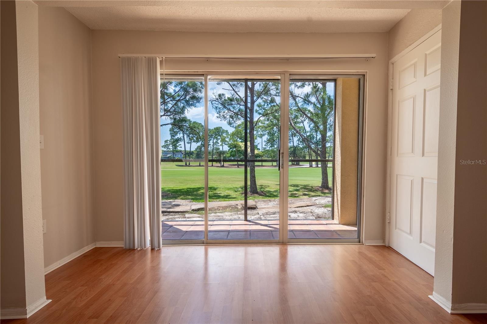 Sliding glass doors in the living room frame a view of the golf course.