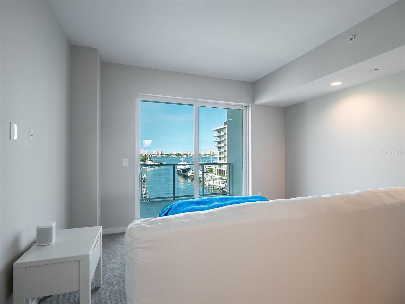 Primary bedroom views to the marina through sliding doors to the private balcony