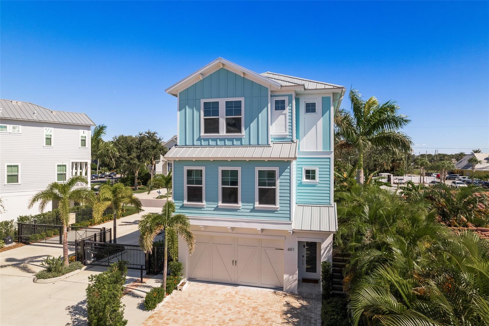 The front of the coastal townhome, dressed in Tiffany blue, exudes an aura of coastal charm and luxury, welcoming residents to a serene retreat by the sea.