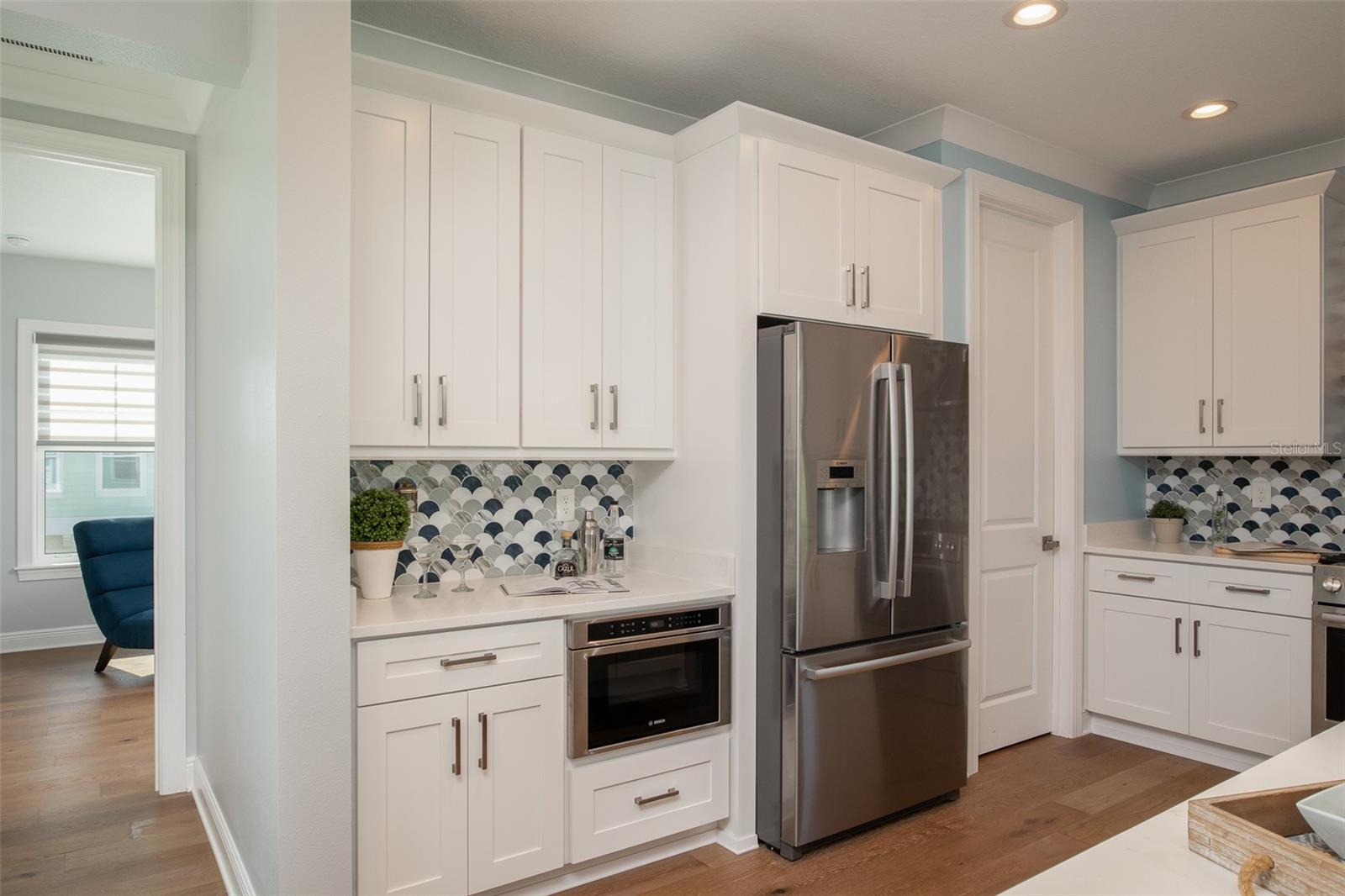 The kitchen features soft-close, beautiful white cabinets, adding a touch of sophistication and functionality to your culinary space, where every detail contributes to the serene coastal ambiance of your home.