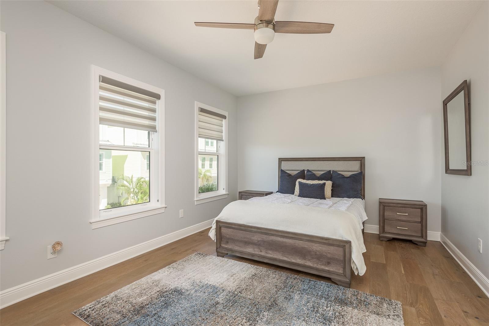 The first bedroom boasts a spacious walk-in closet and a ceiling fan, combining functionality with comfort to provide a serene retreat within your coastal haven, where style meets convenience for a truly luxurious living experience.