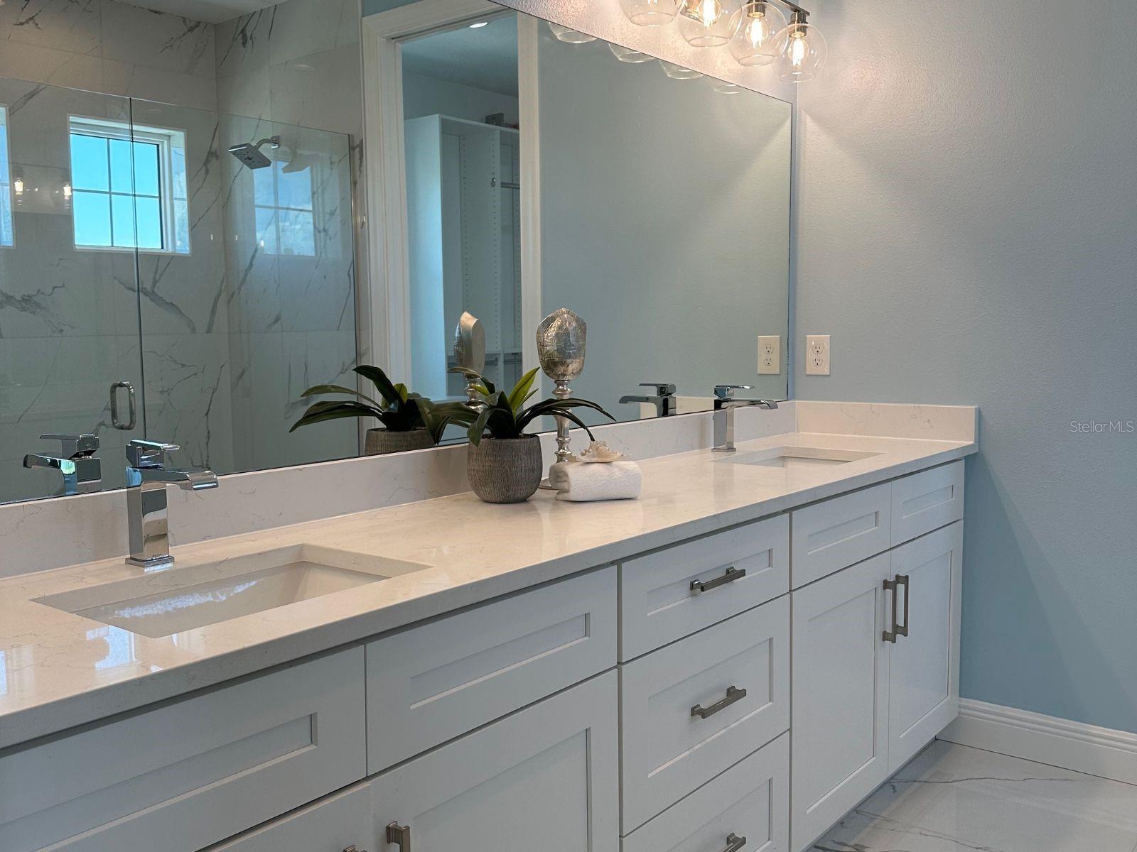 Luxuriate in the en-suite's massive shower, complemented by stone countertops and a dual sink vanity, where every detail is meticulously crafted to enhance your relaxation and elevate your daily routine in this coastal oasis of comfort and style.