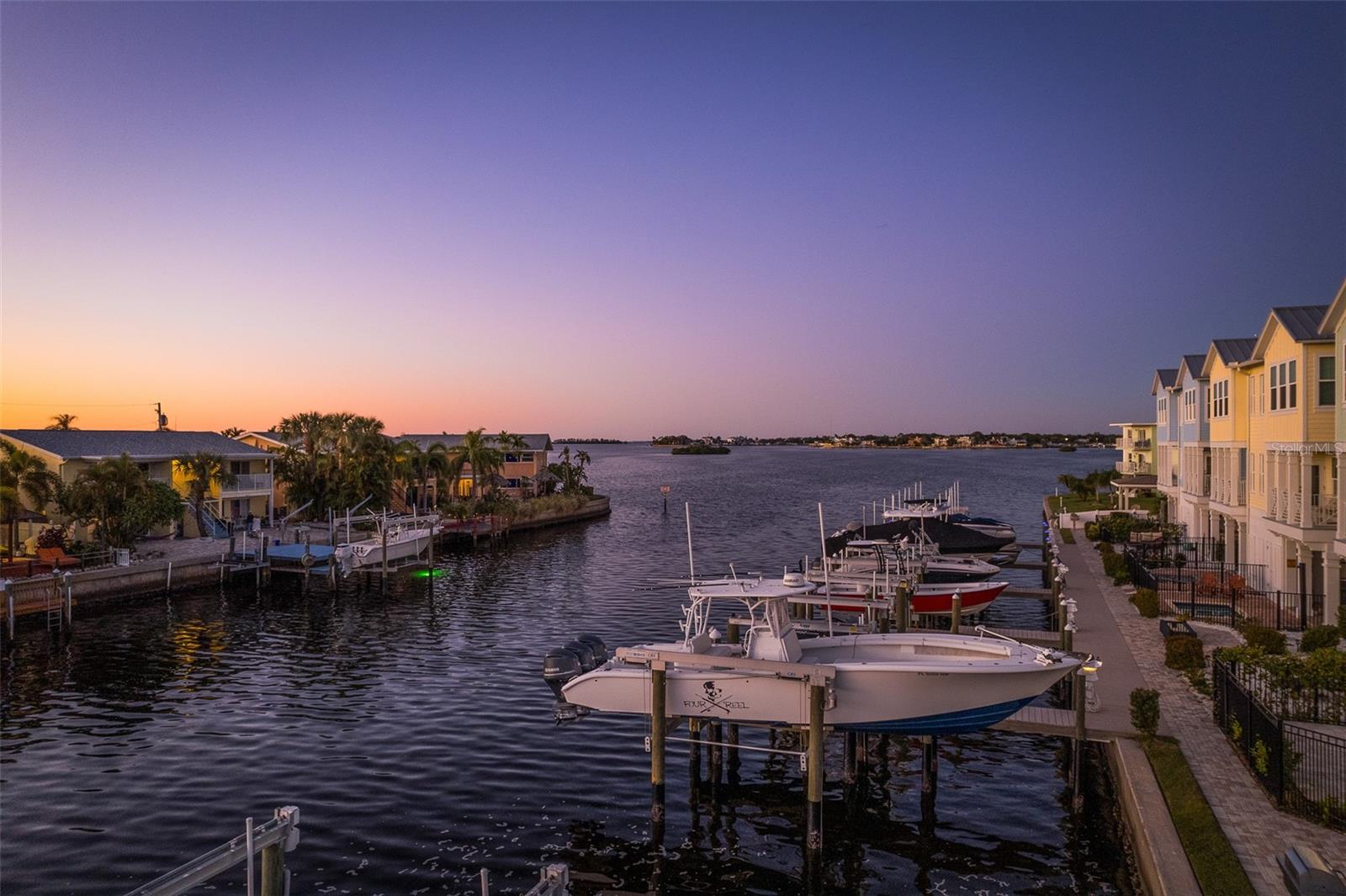Capture the mesmerizing twilight views from the private boat dock, where the serene waters reflect the fading hues of the sunset, creating a picturesque backdrop for your coastal retreat, inviting you to embrace moments of tranquility and beauty by the sea.