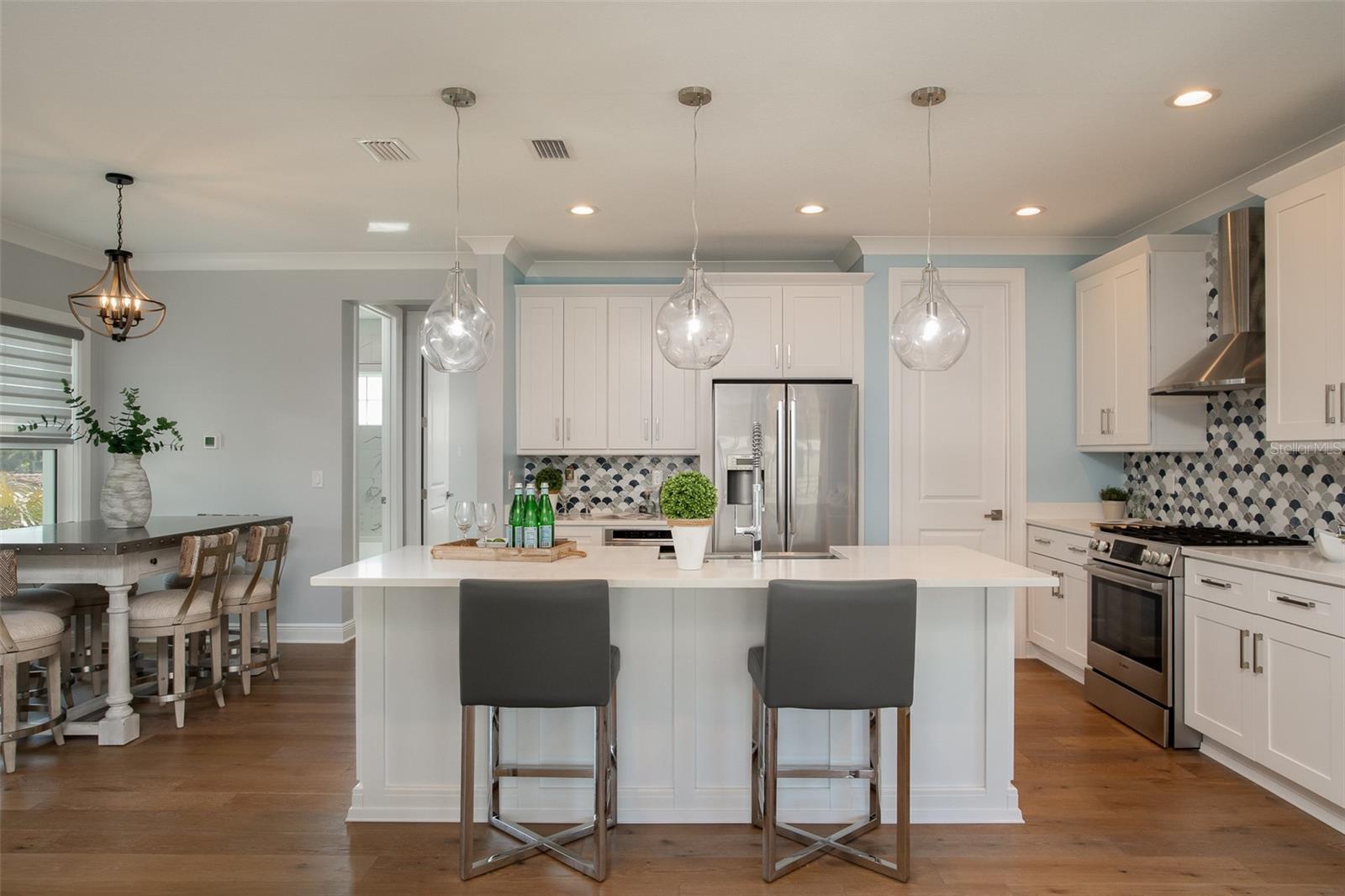 Adjacent to the island, the eating space offers a cozy yet stylish spot to enjoy casual meals or engage in lively conversations, seamlessly blending convenience with coastal elegance in your new home.