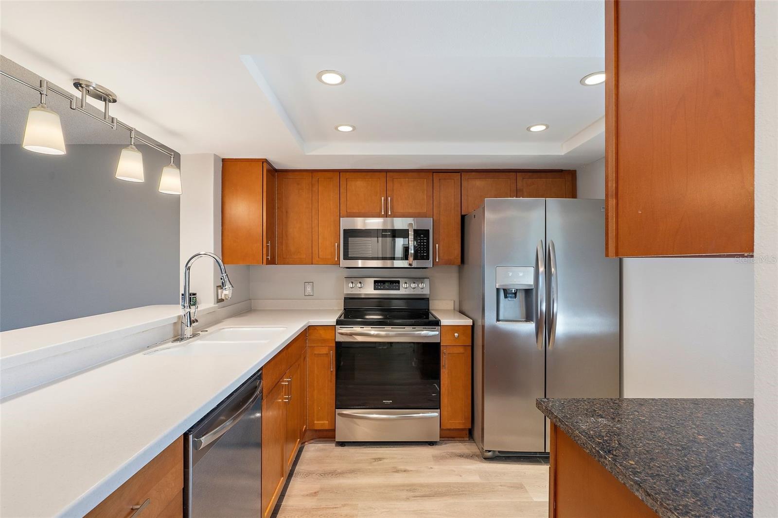 Wood cabinetry, Corian counter tops, porcelain sink, new lighting fixtures and stainless-steel appliances.