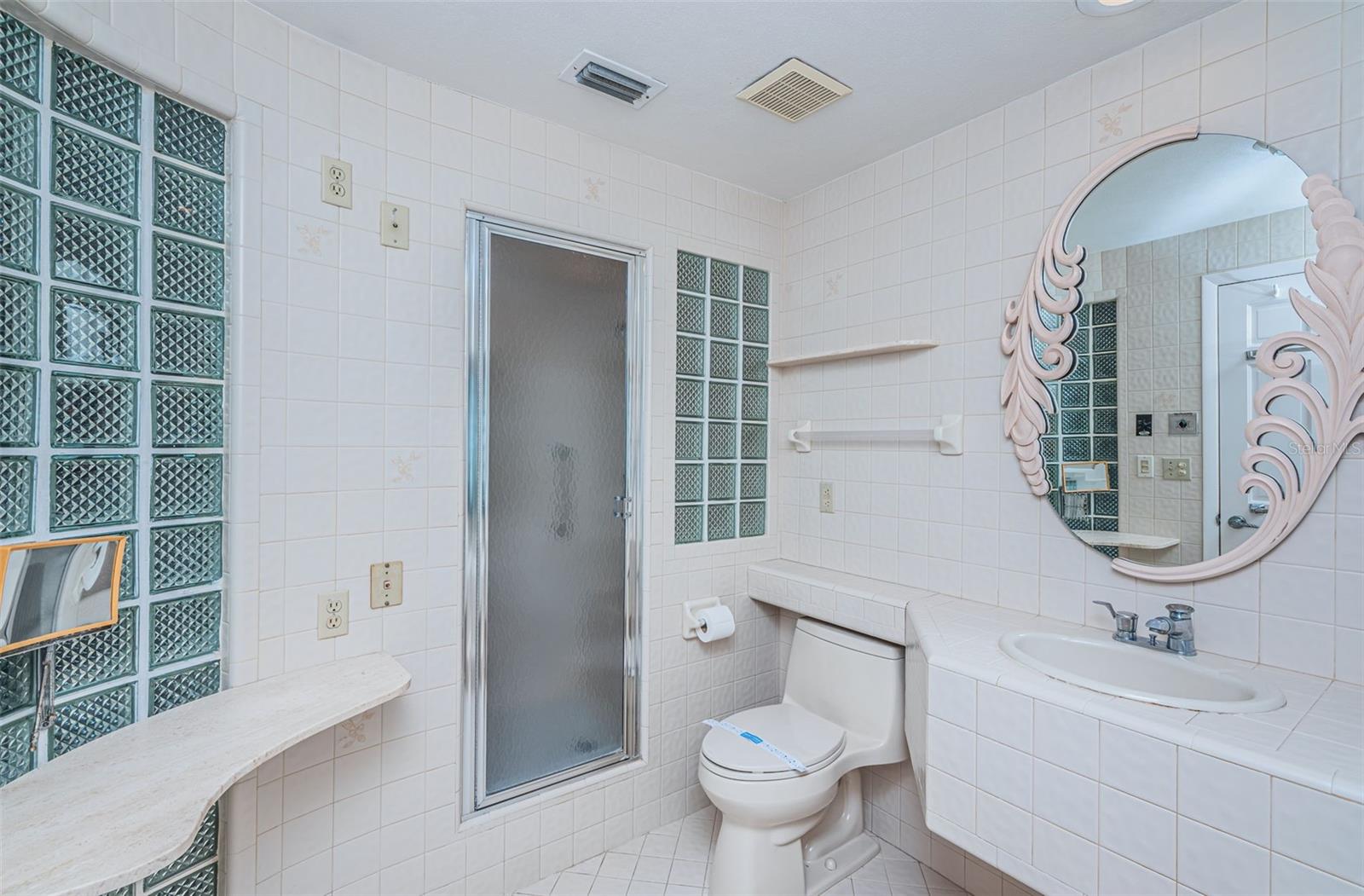 Enjoy comfort and style in the master bathroom of this exceptional property! It features a mirror for your daily routines, a luxurious makeup counter, and a conveniently placed single sink that blends practicality with elegant design.