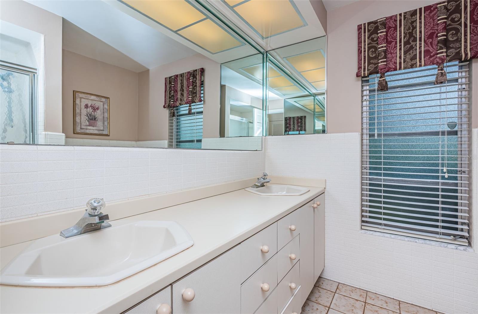The other bathroom is equipped with double sinks, providing convenience for your daily routines. Additionally, there's a convenient cabinet under each sink, offering ample storage for your bathroom essentials.