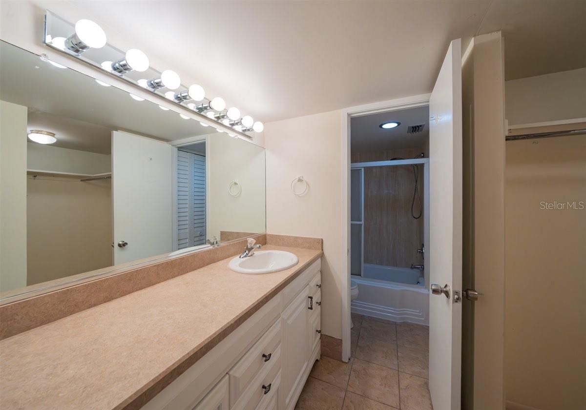 Powder room and door to bathroom with tub and shower.