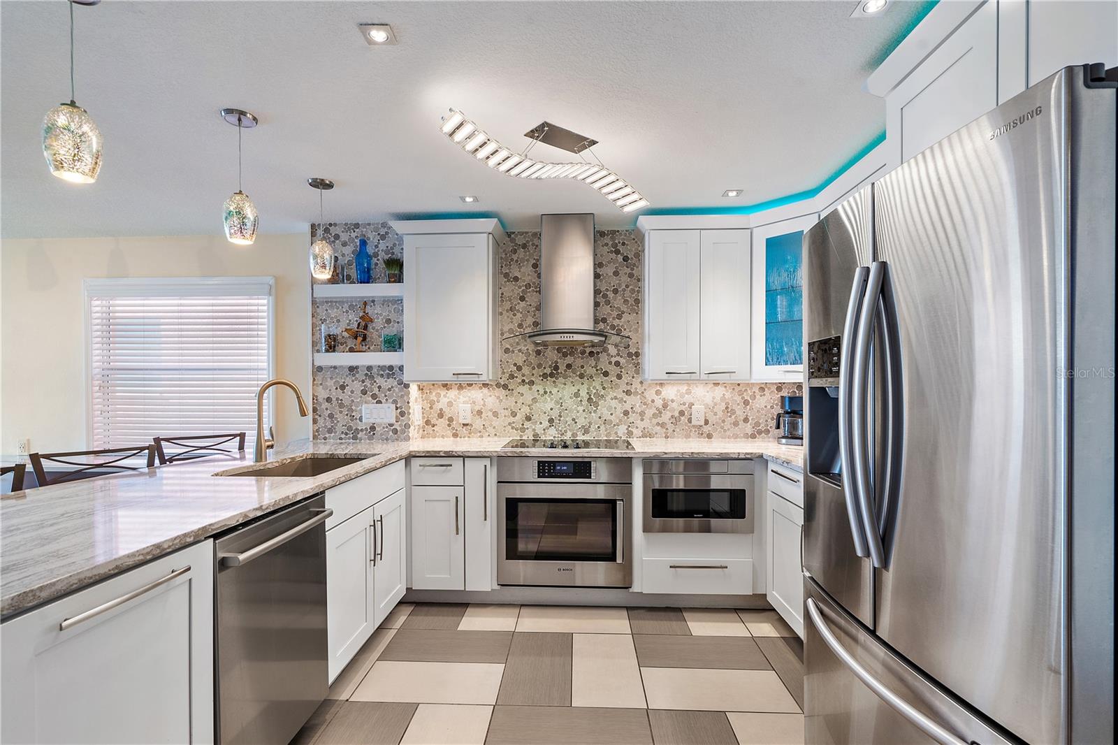 The kitchen was remodeled in 2018 with high-end quartz, plumbing, electric, SS exhaust vent, new SS appliances, recessed lighting, LED lighting, and a central ceiling light with a "wave" design.