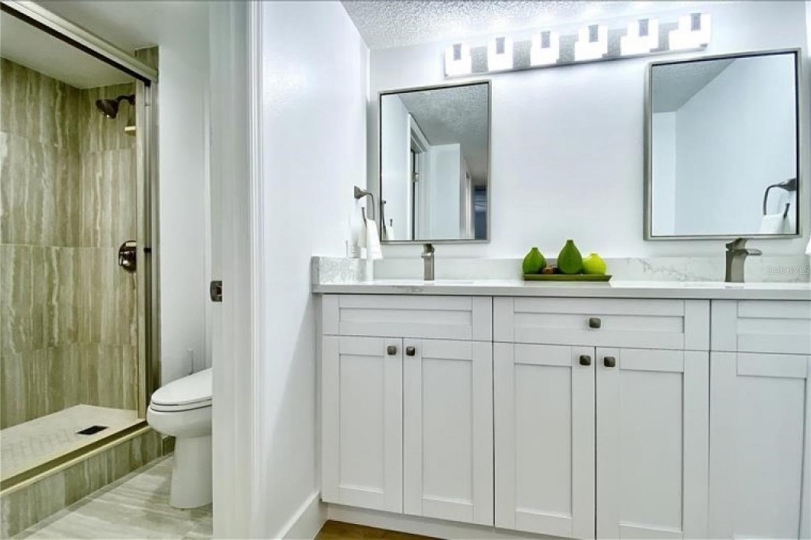 Primary bath with double sinks, granite counters, large step in shower