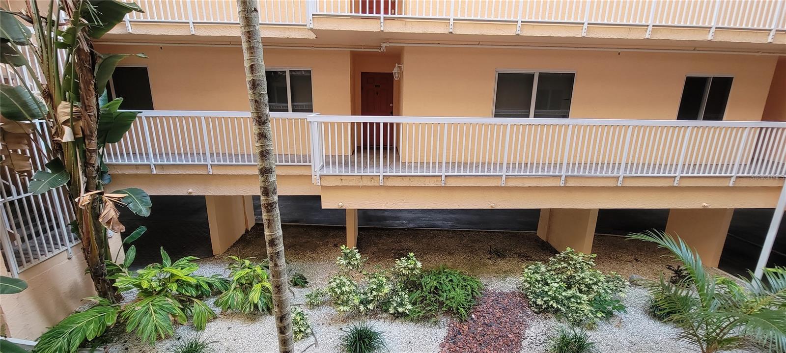 Condo 1104 entrance at center, owner parking surface lot below buildings and pool deck