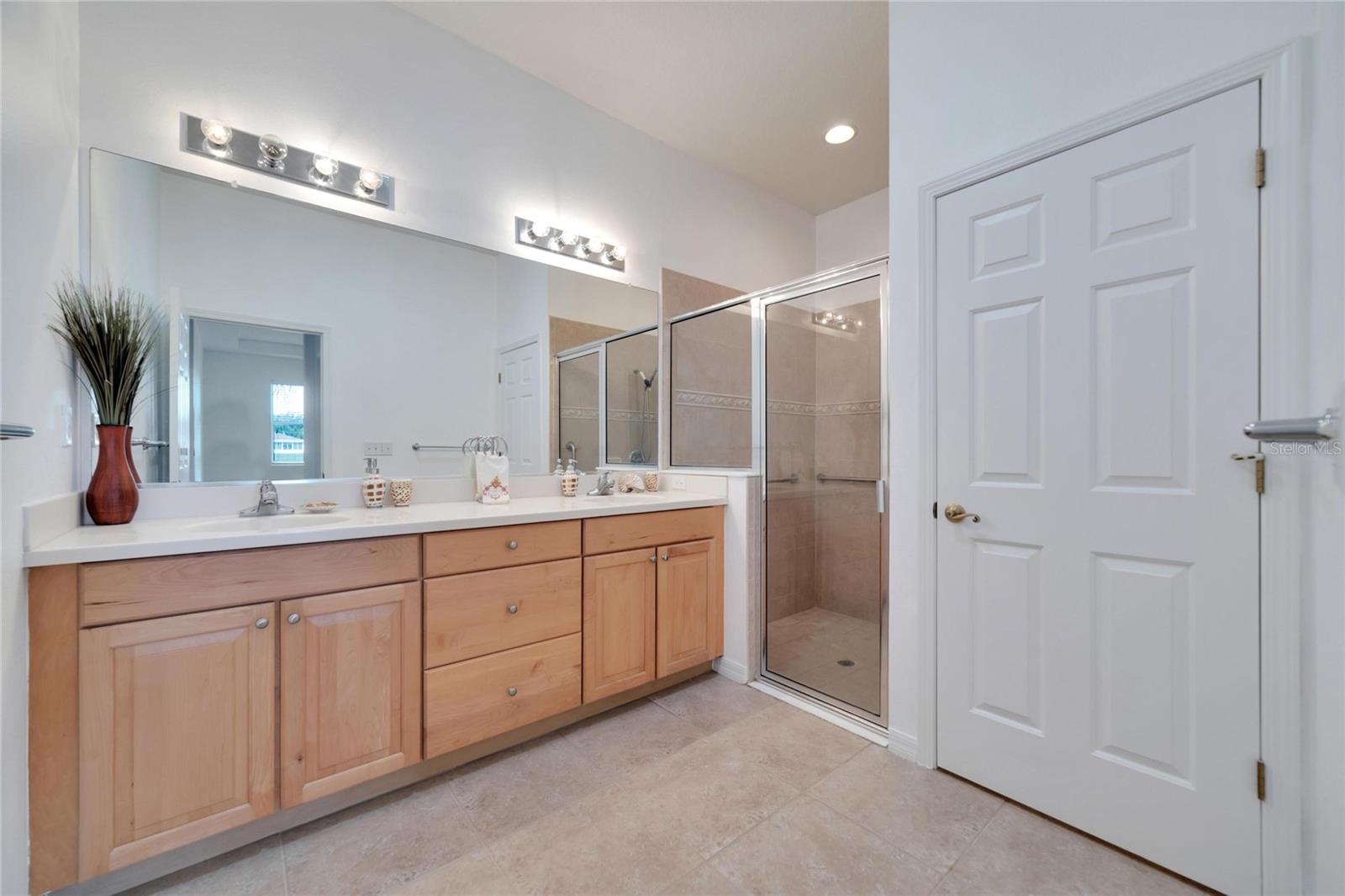 The master bath has twin vanities, high countertops and a huge walk-in shower