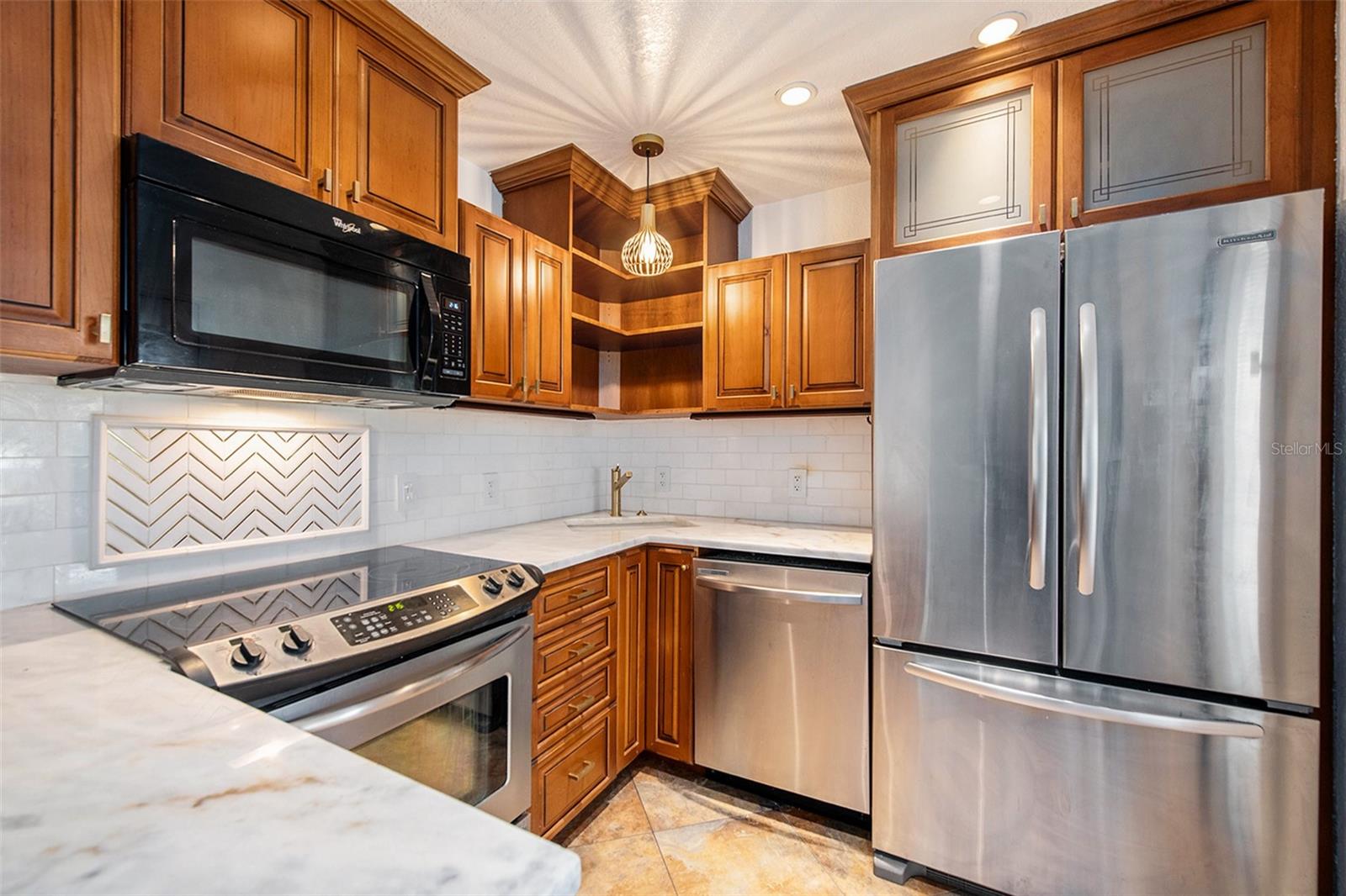 Beautifully updated kitchen with marble counter and a stainless steel appliance package