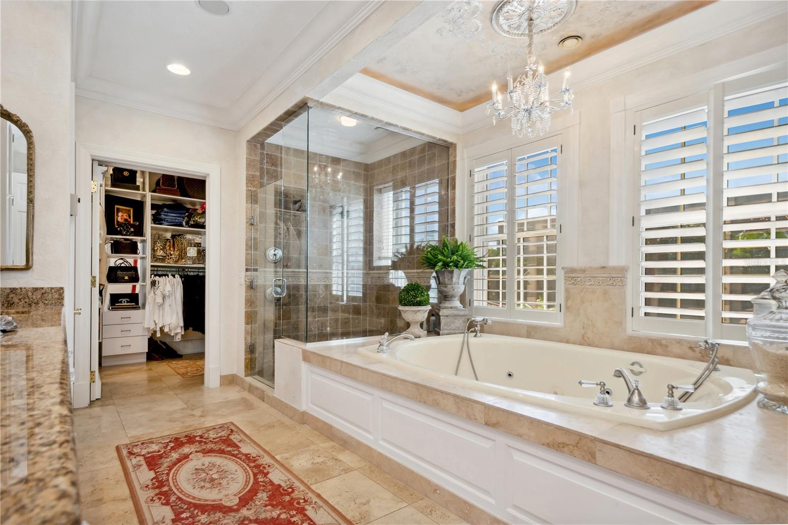 Primary bathroom with glass enclosed stand up shower and spa jacuzzi tub.
