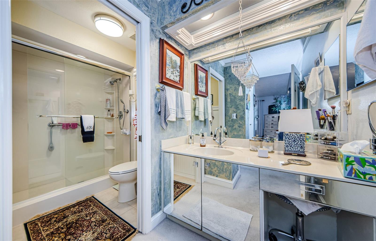 Master vanity area with pocket door to shower with glass doors