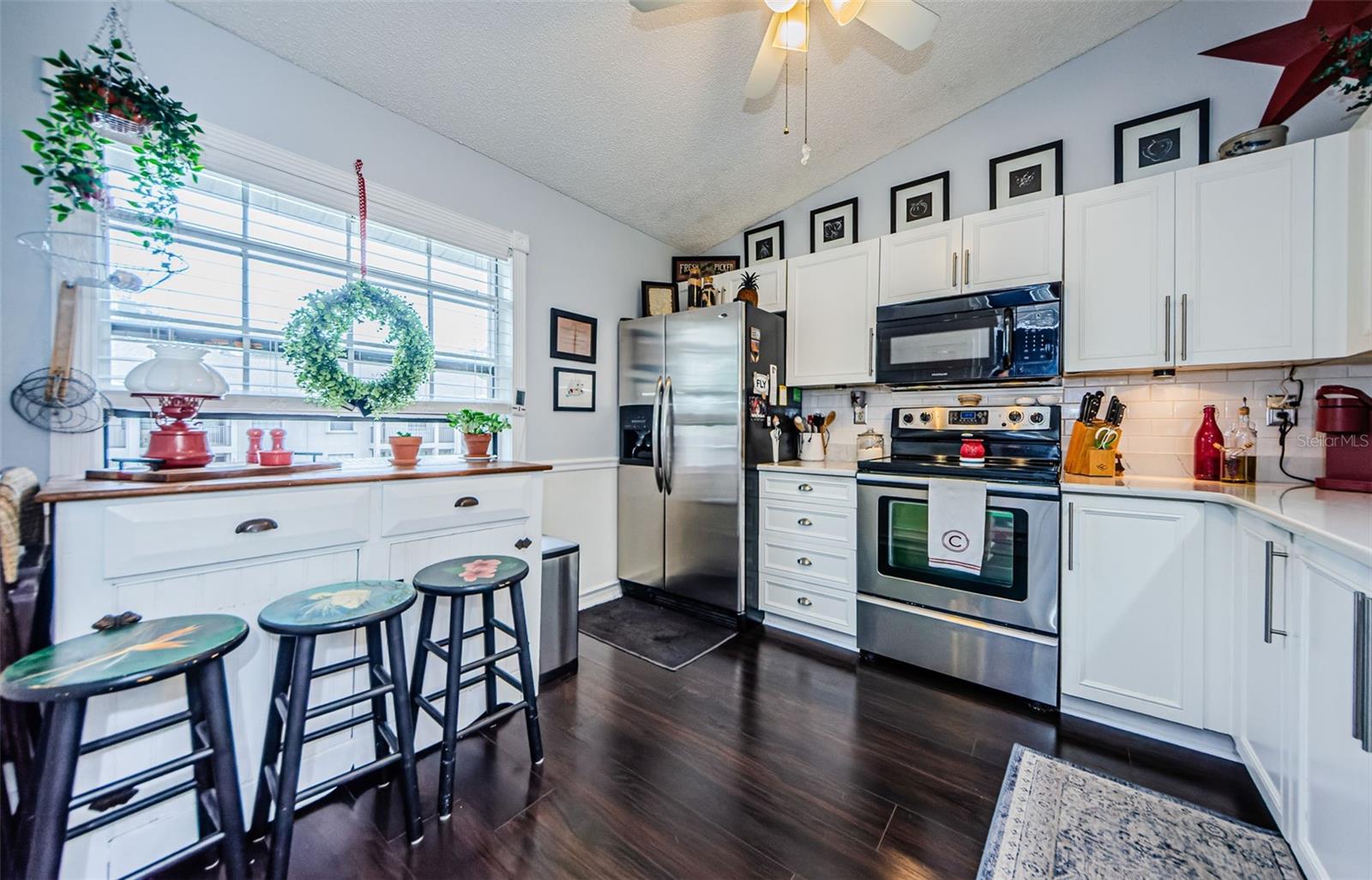 Light and Bright kitchen with gleaming luxury vinyl flooring, stainless steel appliances, and quartz counter tops