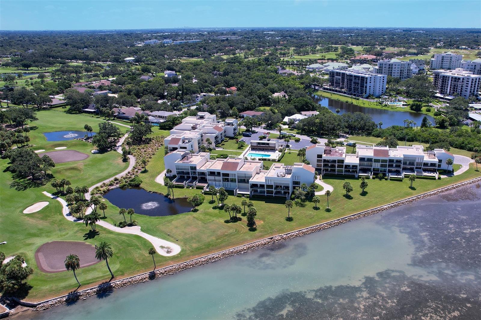 Aerial view of Building 2 in the middle on the golf course and waterfront (Building 1 to the right and Building 3 behind Building 2)