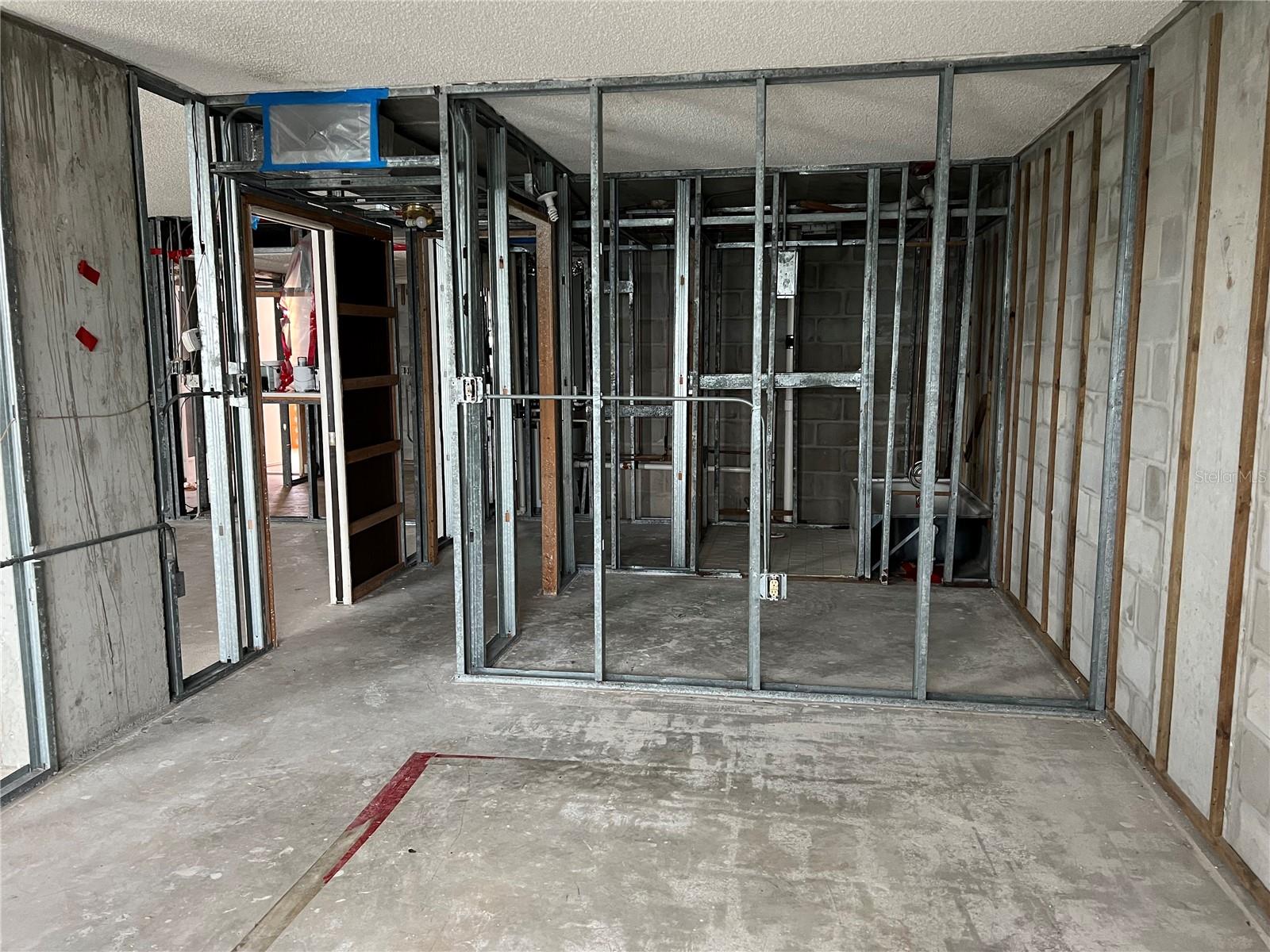 Bedroom looking toward another framed area that could be a small office/bonus room.  Similar condos use this as a very large walk in closet.