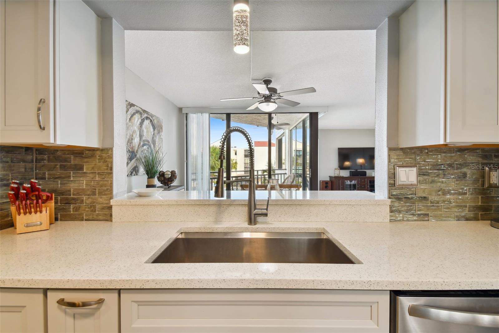 Oversized stainless steel sink is a welcome Kitchen's pass-through counter opens to dining space with balcony views