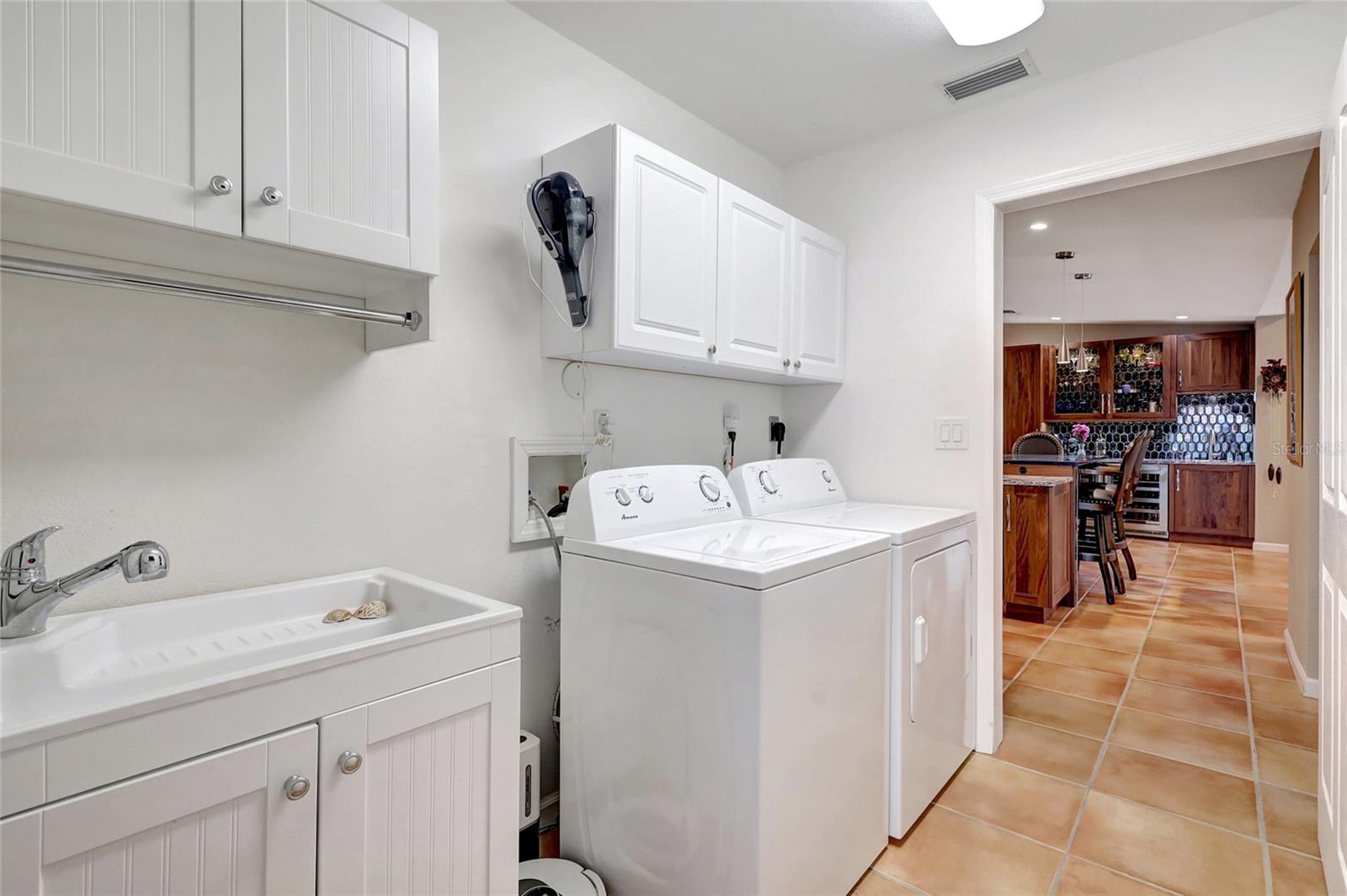 Extra large laundry room adjacent to the well-appointed pool bath behind.