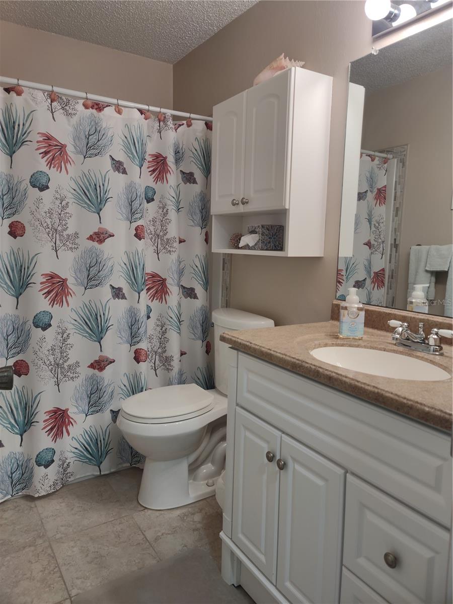 Updated guest bathroom (2019) features raised commode and vanity with solid surface sinktop.