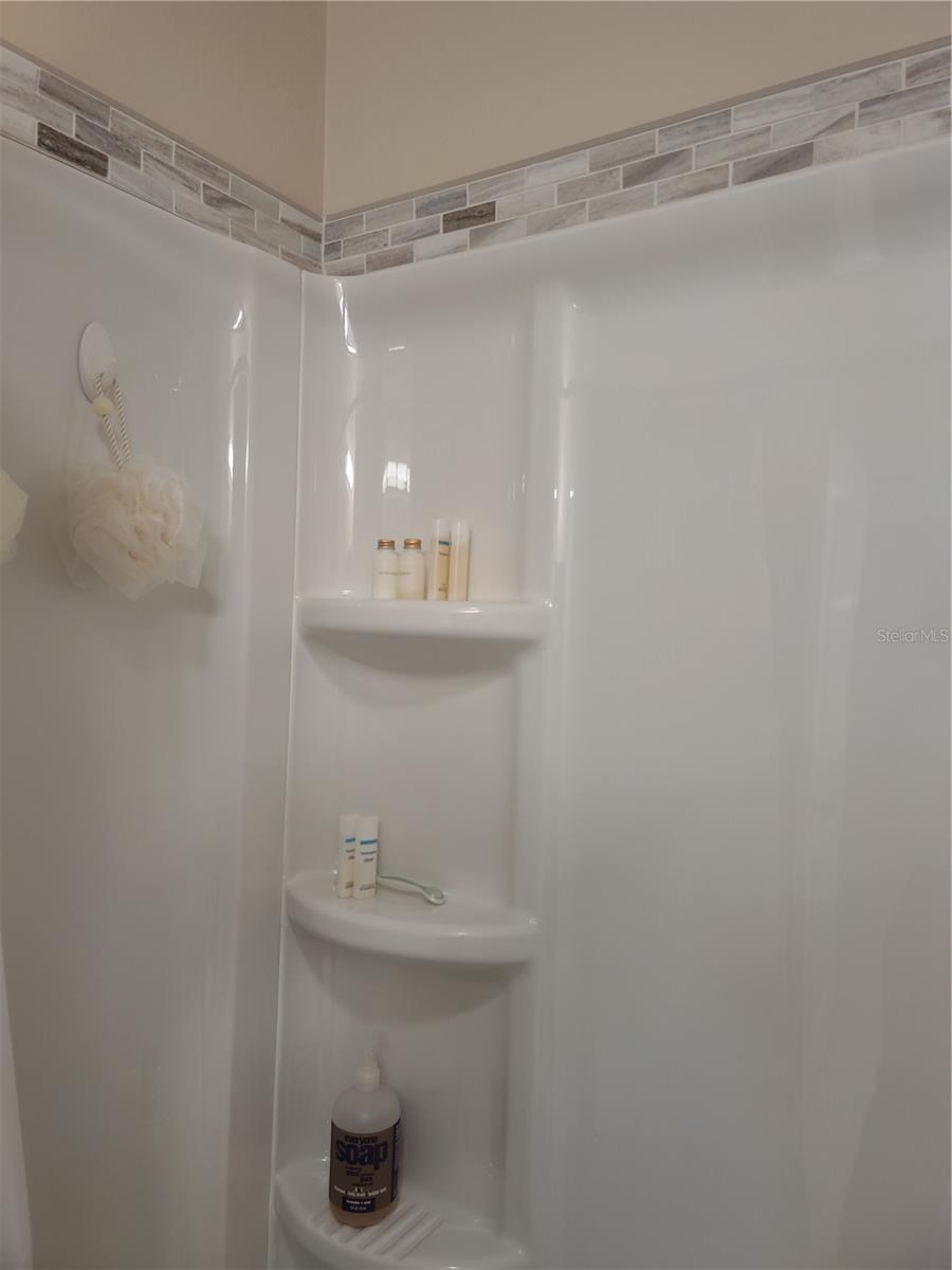 Tub surround is edged with glass tile border.