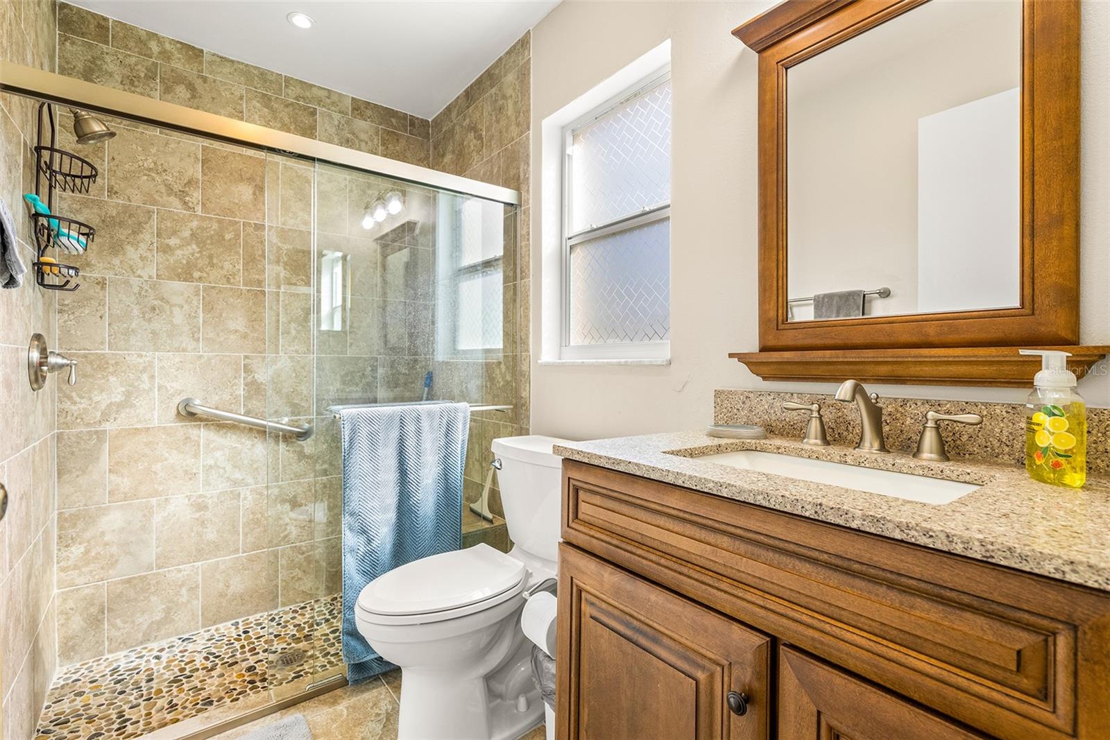 Completely renovated primary bathroom with large, custom tiled walk-in shower, new vanity, flooring & fixtures!