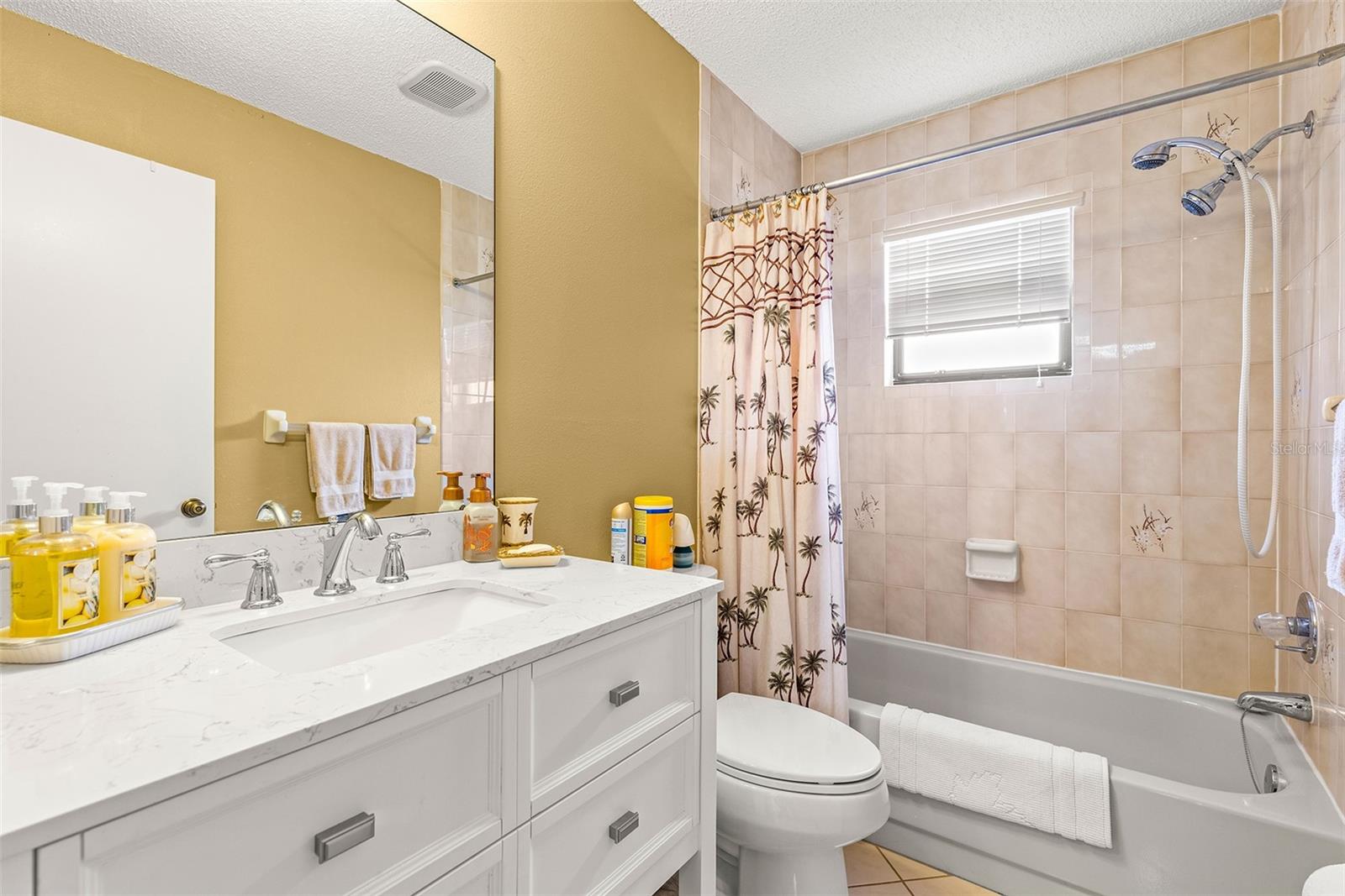 Secondary bathroom features a shower/tub combo with updated vanity and toilet