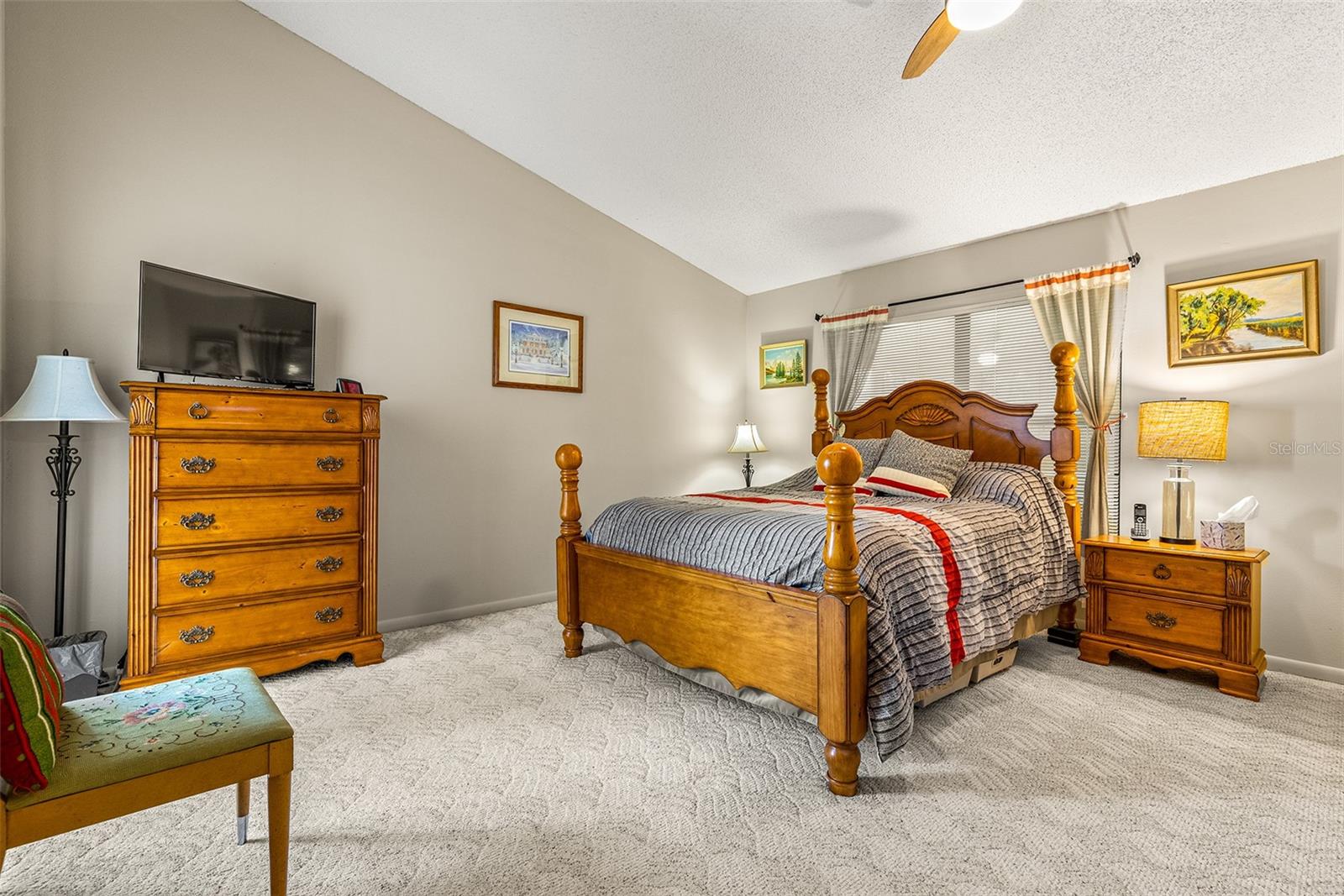 Large primary bedroom with neutral colors, carpeting and includes a en-suite bathroom that has been fully remodeled and large walk-in closet.